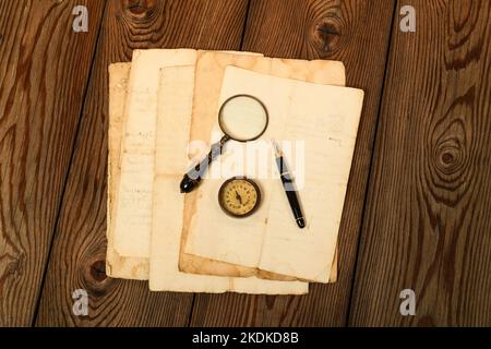 Fountain pen compass and magnifying glass on old sheets Stock Photo