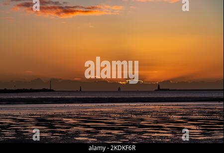 Crepuscular rays over the Irish Sea as the sun rises behind a wall of cloud. Stock Photo
