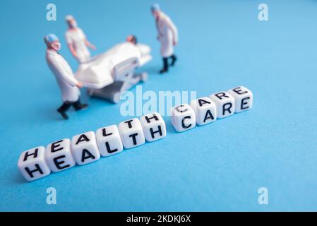 Miniature medical toy people - Health care sentences with blue or teal background Stock Photo