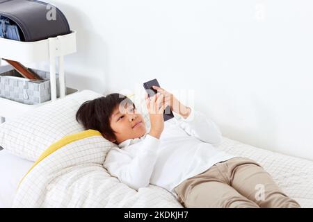 Japanese kid using smartphone at home Stock Photo