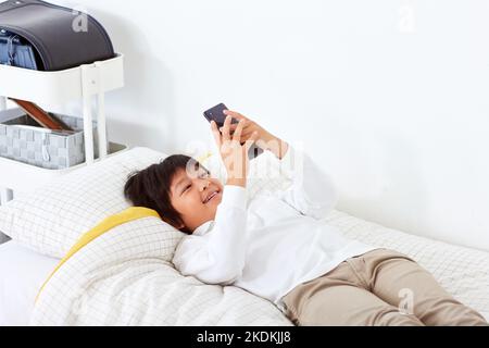 Japanese kid using smartphone at home Stock Photo