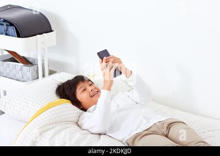 Japanese kid using smartphone at home Stock Photo