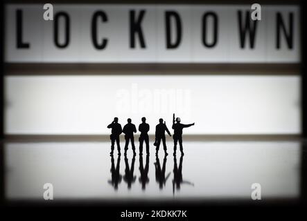 ILLUSTRATIVE EDITORIAL - Lockdown concept images - Low key black and white (b& w) miniature toy figures of security forces - silhouette of army or pol Stock Photo