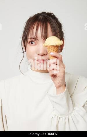 Happy young woman with delicious ice cream in waffle cone outdoors ...