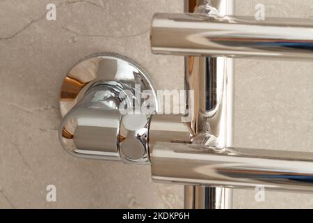 Modern new heated towel rail on a marble wall close-up. Minimalism concept Stock Photo