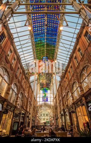 Victoria Quarter, one of the famous Leeds arcades having a brightly coloured, modern, abstract pattern,  stained glass canopy in blue, yellow & red. Stock Photo