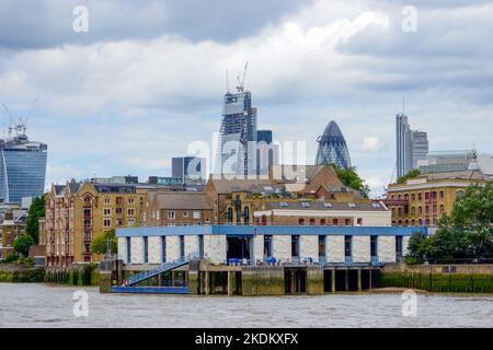 Wapping, London, UK - August 9th 2013: The Metropolitan Police Marine Unit boatyard. In the background is The Walkie-Talkie and Gherkin buildings. Stock Photo