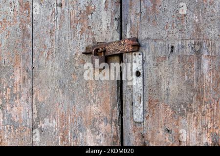 Old grunge wooden door with antique rusty padlock Stock Photo