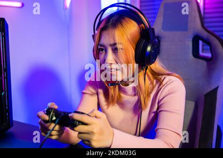 Woman wear gaming headphones playing live stream esports games console Stock Photo