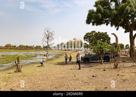 Africa travel - people on a jeep safari stop for coffee by a pool; Moremi Game Reserve, Okavango Delta, Botswana, Africa.  Africa safari holiday. Stock Photo