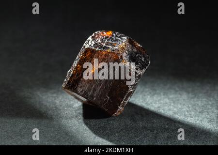 Unpolished Brown Dravite Tourmaline Crystal Back Lit on Black Background Stock Photo