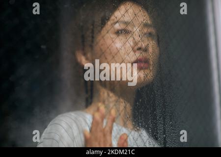 Japanese woman looking out the window Stock Photo