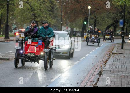 London, UK. 06th Nov, 2022. Participants seen on their 1903 De Dion Bouton Veteran Car as it rains during the run course at Clapham Common. More than 350 veteran cars took part in the annual RM Sotheby's London to Brighton Veteran Car Run. The 60-mile journey to the Sussex coast began at 6am at Hyde Park in London. Credit: SOPA Images Limited/Alamy Live News Stock Photo