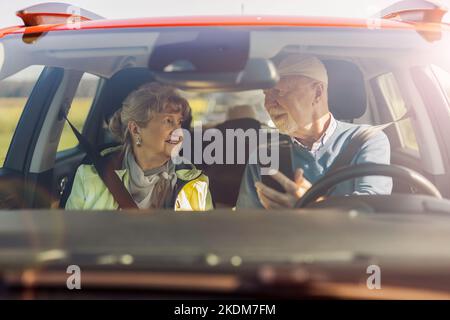 Senior couple using gps on their mobile phone during a road trip Stock Photo