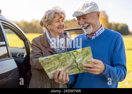 Senior couple looking at map on a road trip Stock Photo