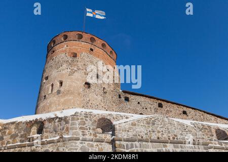 Round tower of Olavinlinna is under blue sky on a sunny day. It is a 15th-century three-tower castle located in Savonlinna, Finland. The fortress was Stock Photo