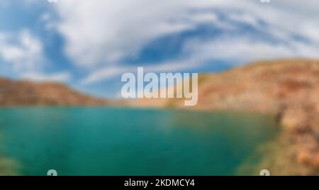 Abstract defocused blured background Emerald lake in a flooded quarry. Emerald green lake in flooded opencast mine. Oval lake in mining industrial Stock Photo