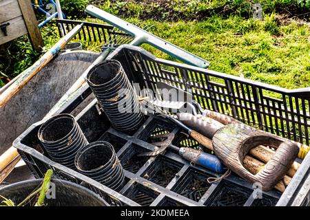 Gardening implements and tools including rakes, pots, forks etc in garden. Horticulture hobby garden tools. Surrey allotment garden.UK Stock Photo