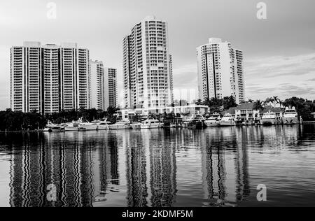 Aventura, Miami, Florida, USA - November 6, 2022: Aventura Landscape in black and white from Waterway with skyrisers, water channel, boats and skies Stock Photo