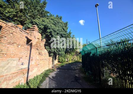 Gravel  path next to a brick wall in a park at sunset Stock Photo