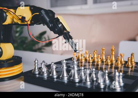 Closeup yellow robot arm playing move chess on chessboard Stock Photo