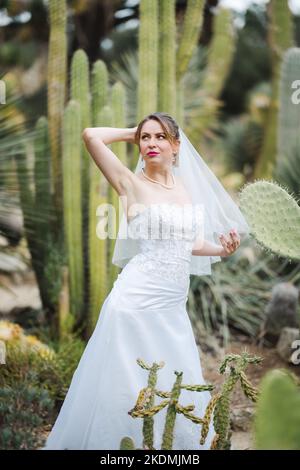 Bride Surrounded by Cactus Plants in a Garden During the Late Afternoon Stock Photo