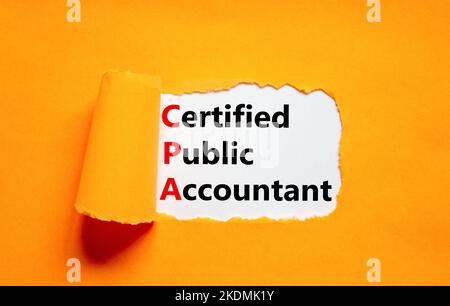 CPA certified public accountant symbol. Concept words CPA certified public accountant on white paper on a beautiful orange background. Business and CP Stock Photo