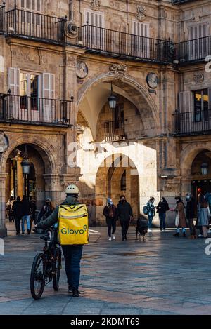 Salamanca, Spain - January 14, 2022: Glovo rider in Plaza Mayor of Salamanca. Stock Photo