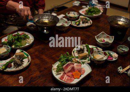 A traditional Japanese meal at a ryokan, featuring pork shabu shabu and seasonal produce, Chojukan Ryokan, Hoshi Onsen, Japan. Stock Photo