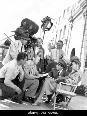 Cinematographer JAMES WONG HOWE Director VINCENT SHERMAN ROBERT ALDA and ANN SHERIDAN on set location candid with Camera / Movie Crew during filming of NORA PRENTISS 1947 director VINCENT SHERMAN music Franz Waxman wardrobe Travilla Warner Bros. Stock Photo