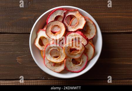 Dried apple rings in white bowl, top view Stock Photo