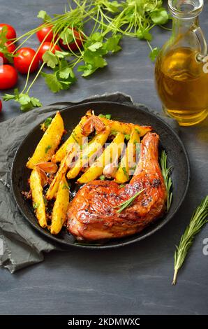 Fried chicken leg and potato wedges on plate Stock Photo