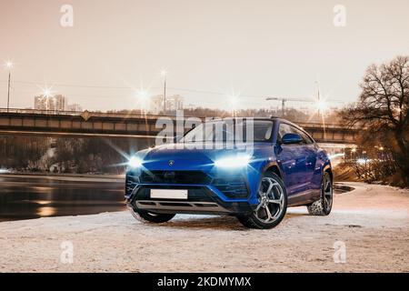 Moscow, Russia - December 14, 2020 : Blue Lamborghini Urus New super SUV car. Ssuv on the street. Snow winter evening, front view, headlights on Stock Photo