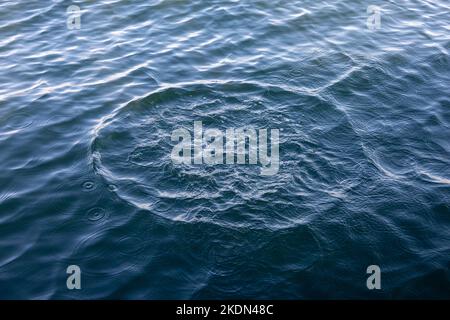 Water circles on the sea. Water rings after throwing a stone. Background or wallpaper. Stock Photo