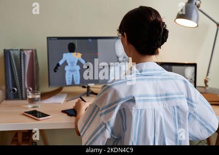 Back view of female designer building 3D models and using computer at home office workplace Stock Photo