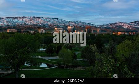 With Ann Morrison Park in the foreground and the mountains in the background, the springtime sun sets on downtown Boise, Idaho Stock Photo