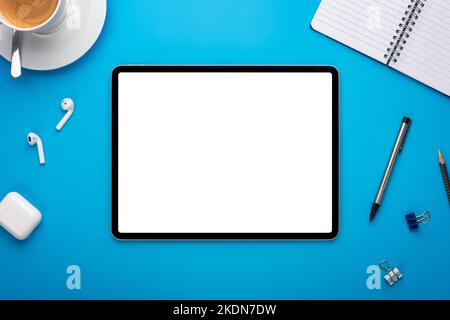 Notebook and Tablet Computer on Blue Desk or background laying flat on Creative workplace as mockup or Template with empty or blank page or screen Stock Photo