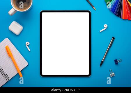 Notebook and Tablet Computer on Blue Desk or background laying flat on Creative workplace as mockup or Template with empty or blank page or screen Stock Photo