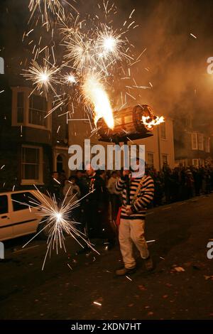 Jason Winter, Captain of Tar Barrels for Borough, carries a flaming barrel flaming Roman Candle in the main procession of the evening. Stock Photo