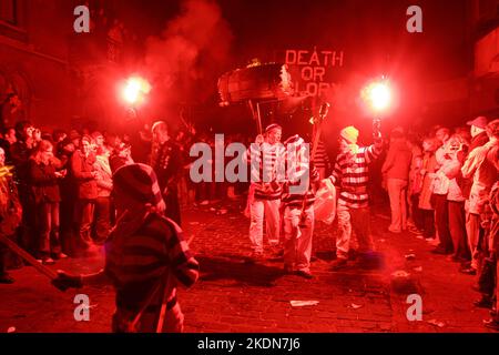 Jason Winter, Captain of Tar Barrels for Borough, carries a flaming barrel along the main street of Lewes. Stock Photo