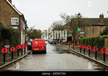 Harmondsworth, UK. 5th November, 2022. Large red poppies are pictured fixed to bollards lining a pavement in Harmondsworth village. Remembrance Day, a Stock Photo