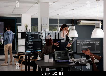 Database web developers developing source code and cloud computing in it big data office room. African american programmer typing on keyboard to create artificial intelligence script. Stock Photo