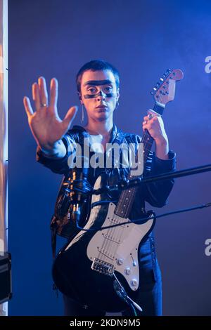 Stop Sign Singer Modern musician doing stop sign with palm and listening to sounds in ...