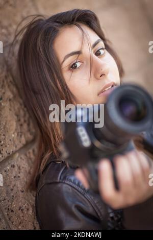 Young Adult Iranian Female Photographer Against Wall Holding Camera. Stock Photo