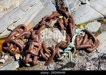 Old rusty chain at Harrow harbour, near the village of Scarfskerry, near Thurso, Caithness, Scotland, UK Stock Photo