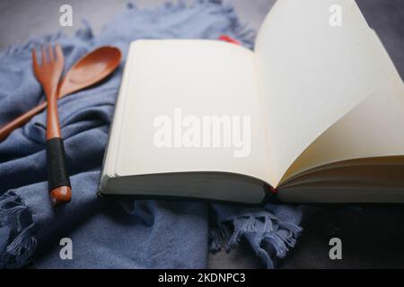 open notepad and wooden spoon on table cloth  Stock Photo