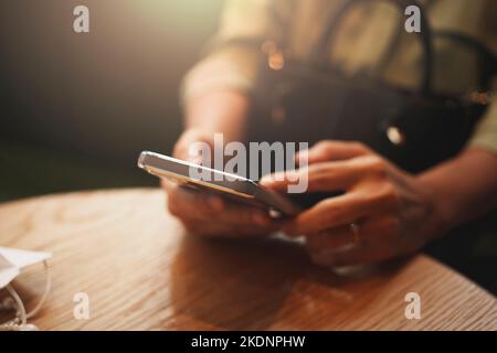 Close-up of woman's hand using a smartphone during coffee break. Stock Photo