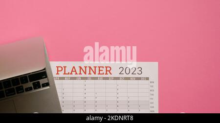 2023 Planner Calendar with computer laptop. Top view, copy space. Stock Photo