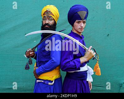 Mumbai, India. 07th Nov, 2022. Nihangs or Sikh warriors pose for a photo while holding swords ahead of the birthday celebration of Guru Nanak Dev Ji in Mumbai. Gatka is a Punjabi word that translates to wooden sticks, which are used instead of swords. it uses a sword as the main weapon, amongst others. person's spiritual and physical aspect is developed during the learning phase of this ancient art. Gatka was extensively used by Sikh warriors to defend themselves from the atrocities of the Mughals and the British rulers. Credit: SOPA Images Limited/Alamy Live News Stock Photo
