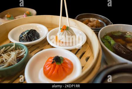 Die cut of white Xiao long bao and set dim sum on black isolated. Stock Photo